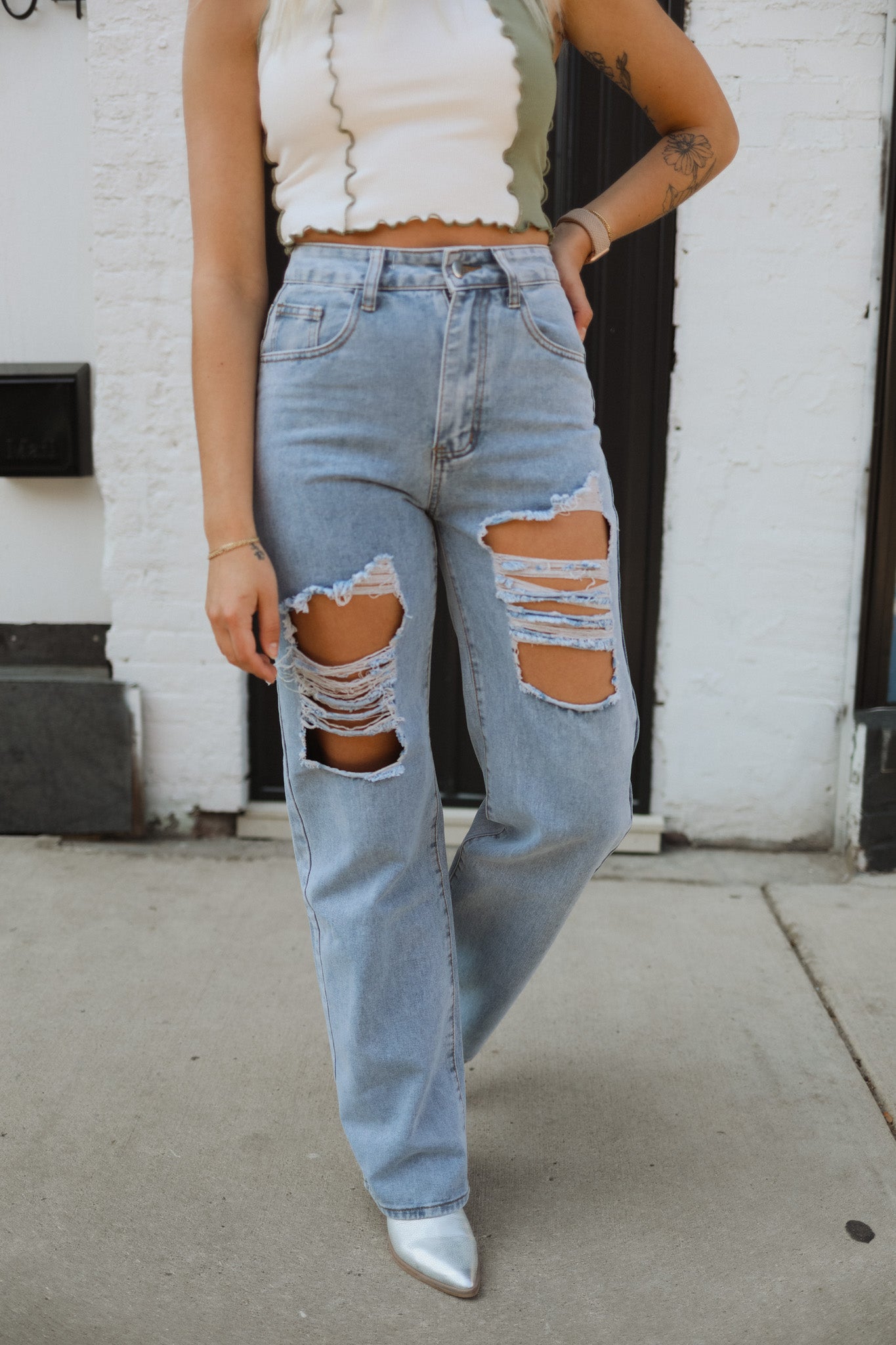 Fashion-forward design features a high-waisted silhouette, straight leg, distressed details, and ripped holes for an acid-washed, overdyed look in a boyfriend-mom jean.