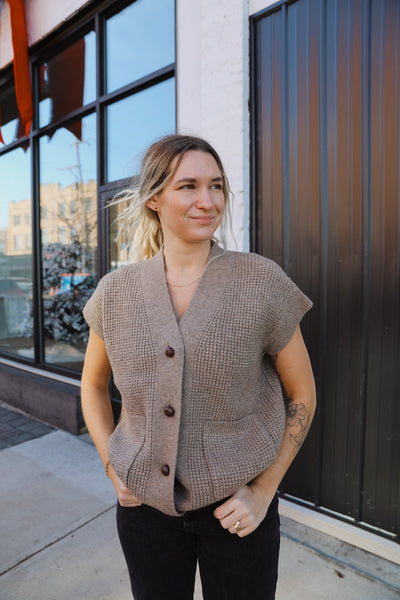 Classic taupe-hued waffle knit vest featuring button-down closure.
