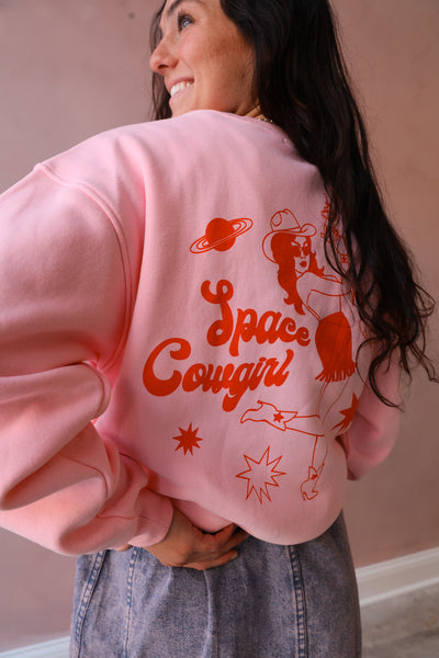 This pink cowgirl pullover features a striking red print, making it a standout piece in any wardrobe.