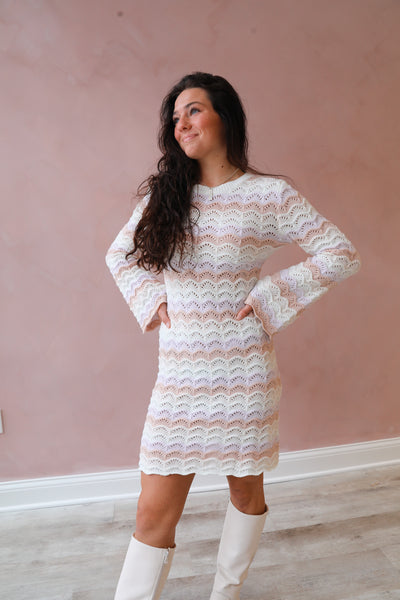 This round-neck sweater dress features ivory multi print and bell sleeves for a stylish and comfortable look.