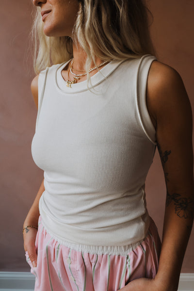 The Julia Top is a soft-ribbed tank with modern details to elevate a classic silhouette. It features a scoop neckline and wide band detailing.